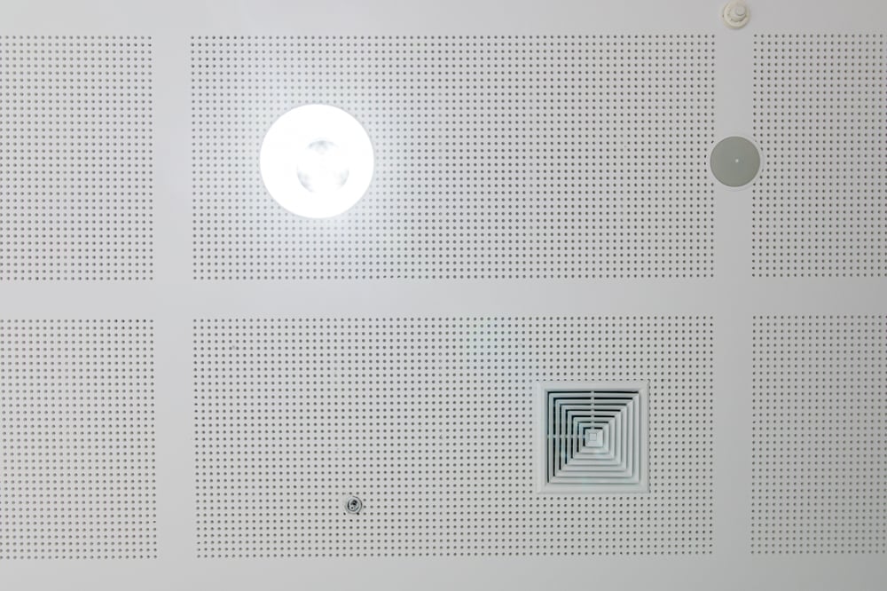 Acoustic ceiling panels designed to absorb sound and reduce noise in a workspace