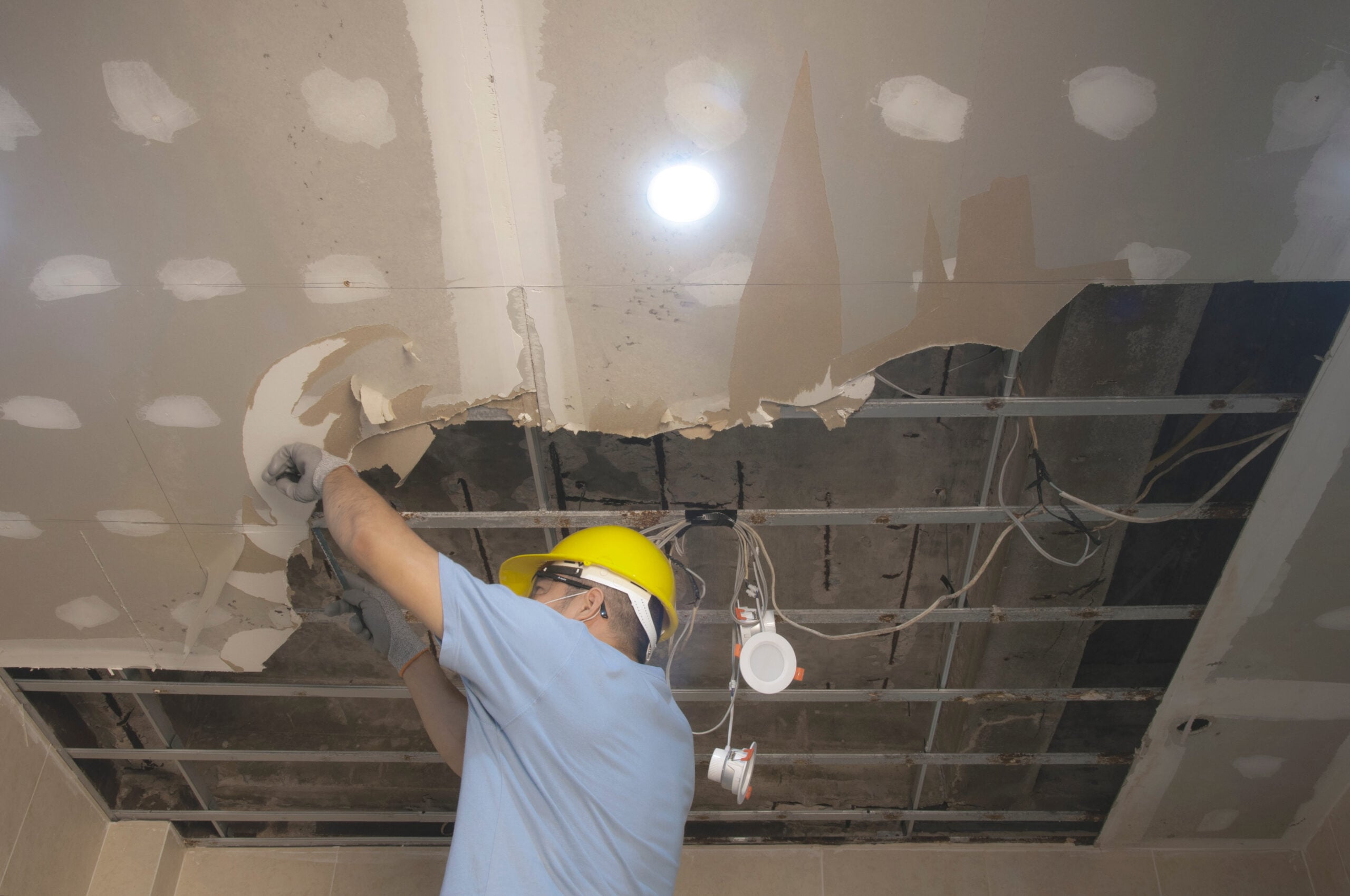 Home,Renovate.,A,Man,Fix,Ceiling,From,Water,Leak.,Water Home renovation worker repairing a water-damaged ceiling, highlighting maintenance work on interior ceiling surfaces.