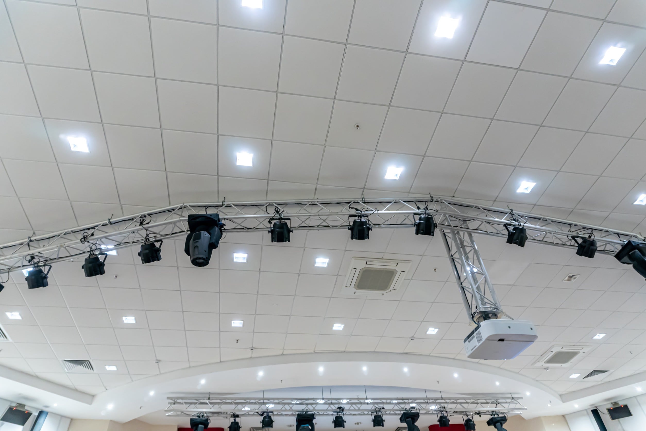Copy of Theater Installation Commercial ceiling system with suspended acoustic ceiling tiles, integrated LED lighting, HVAC vents, and event rigging in a modern commercial facility.