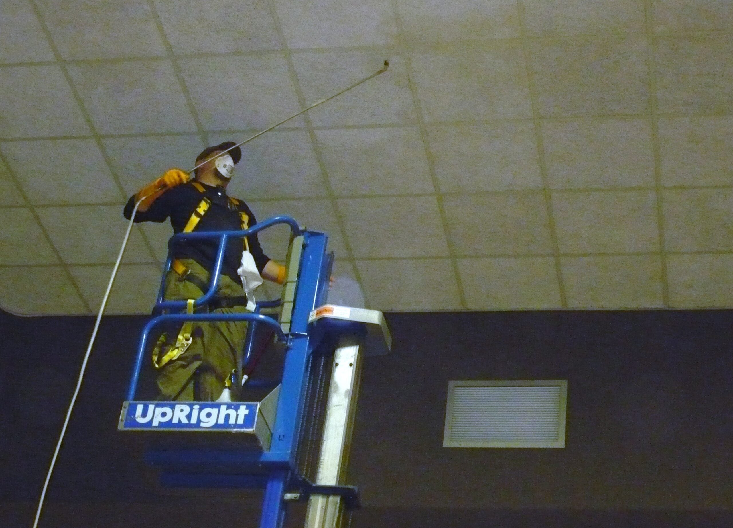Commercial ceiling cleaner using a lift to clean a large ceiling.